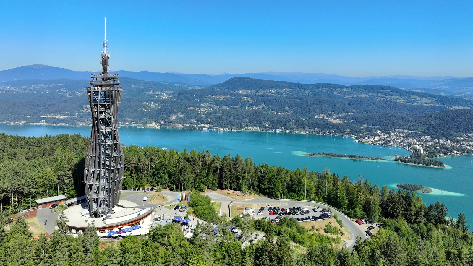 Aussichtsturm Pyramidenkogel aus der Luft, dahinter der türkisfarbene Wörthersee